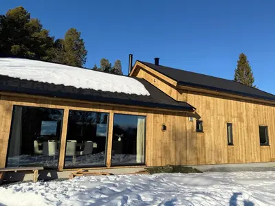 a house in the snow with a large window at Ny hytte i vakre Oppdal, Norge in Fagerhaug
