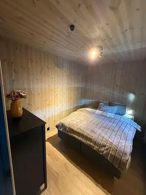 a bedroom with a bed in a room with wooden walls at Ny hytte i vakre Oppdal, Norge in Fagerhaug