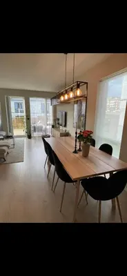 a dining table and chairs in a living room at Rekkehus til SKI-VM in Lund
