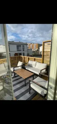 a balcony with couches and tables on a building at Rekkehus til SKI-VM in Lund