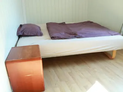 a small bed in a room with a wooden floor at Trysil sentrum leilighet in Trysil