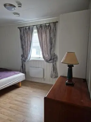 a bedroom with a bed and a table with a lamp at Trysil sentrum leilighet in Trysil