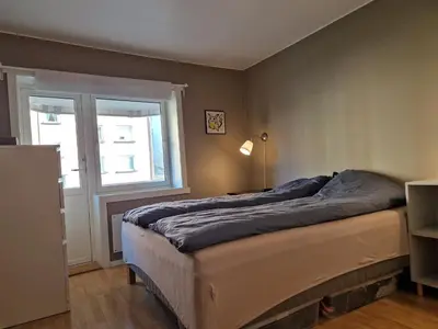 a bed in a room with a window and a bed sidx sidx sidx at Central and cosy apartment in Trondheim, Free parkingspot in Trondheim