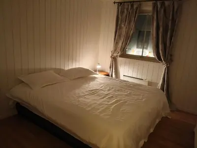 a bedroom with a bed with white sheets and a window at Trysil sentrum leilighet in Trysil