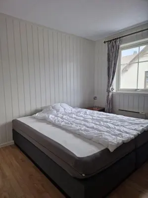 a large bed in a bedroom with a window at Trysil sentrum leilighet in Trysil