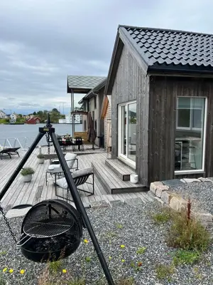 a camera on a wooden deck next to a house at Amundøya Boathouse in Vadstensvik