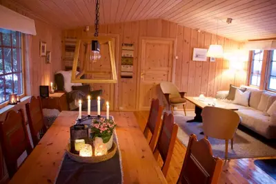 a living room with a table with candles on it at Koselig familiehytte på Rømåsen in Ringsaker
