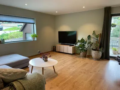 a living room with a couch and a tv at Presthusvegen in Trondheim