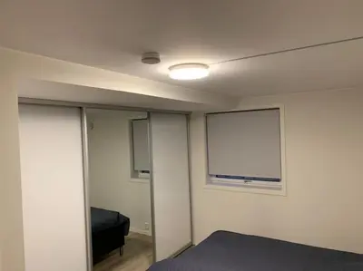 a bedroom with a bed and a window in it at Moderne og fullt utstyrt 3-rom hageleilighet sentrum nær in Bergen