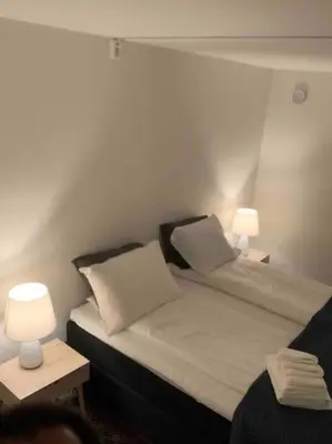 a bedroom with two beds and two lamps on tables at Moderne og fullt utstyrt 3-rom hageleilighet sentrum nær in Bergen