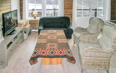 a living room with a table and two chairs and a television at Nice Home In Straumgjerde With Wifi in Brunstad