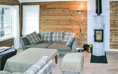 a living room with a couch and a fire place at Nice Home In Straumgjerde With Wifi in Brunstad