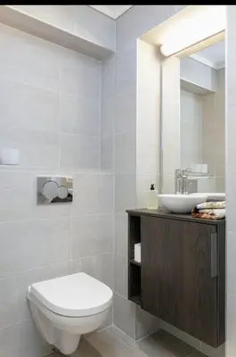 a bathroom with a white toilet and a sink at Downtown free parking cozy apartment in Ålesund