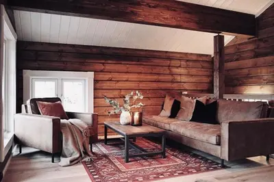 a living room with a couch and a table at Tømmerhus i Geiranger Sentrum med panorama utsikt in Geiranger