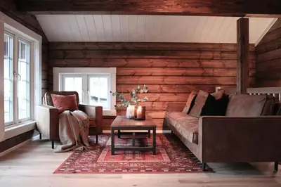a living room with a couch and two chairs at Tømmerhus i Geiranger Sentrum med panorama utsikt in Geiranger