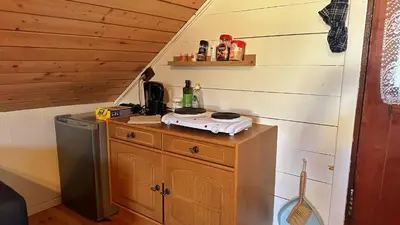 a kitchen with a stove on top of a wooden cabinet at Cozy Cabin in Volda