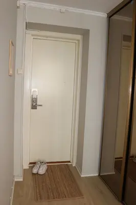 a white door with a pair of shoes on the floor at One-bedroom apartment close to NTNU and St Olavs in Trondheim