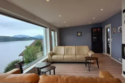 a living room with a couch and a large window at Villa with a view in Ålesund