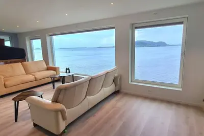 a living room with a couch and a large window at Villa with a view in Ålesund