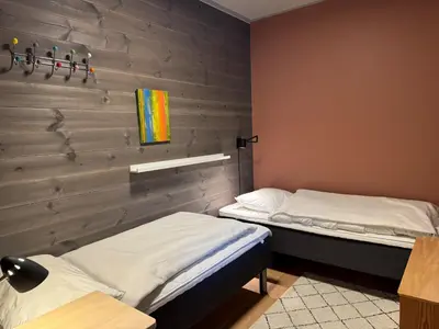 two beds in a room with a brick wall at Riddertunets toppleilighet in Beitostøl