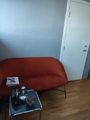 a red couch in a room with a table at Separate rooms in a large house,on the E6 road in Biri