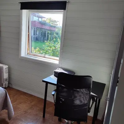 a desk and a chair in a room with a window at Separate rooms in a large house,on the E6 road in Biri