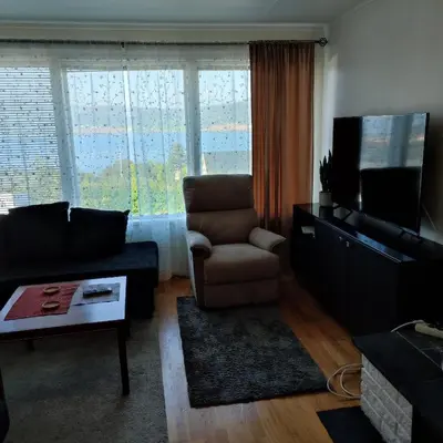 a living room with a couch and a chair and a television at Separate rooms in a large house,on the E6 road in Biri