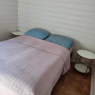 a small bedroom with a bed and two tables at Separate rooms in a large house,on the E6 road in Biri