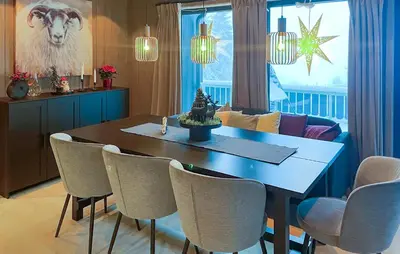 a dining room with a table and a cow on the wall at 5 Bedroom Stunning Home In Løten in Løten