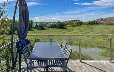 a table and chairs on a deck with an umbrella at Nice Home In Lysøysundet With Wifi in Lysøysund