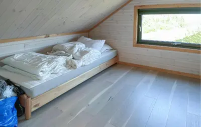 a bed in the corner of a room with a window at Nice Home In Lysøysundet With Wifi in Lysøysund