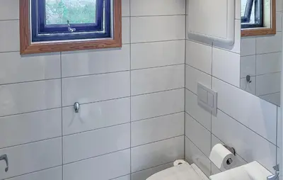 a white bathroom with a toilet and a window at Nice Home In Lysøysundet With Wifi in Lysøysund