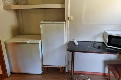 a small kitchen with a refrigerator and a microwave at House in Austevoll in Austevoll