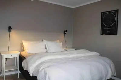 a bedroom with a large white bed and a nightstand at Entire house less than 2 km from Granåsen, WC 2025 in Trondheim