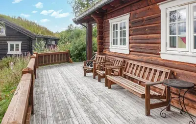 a wooden cabin with benches on a deck at 2 Bedroom Lovely Home In Oppdal in Oppdal