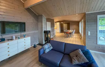 a living room with a blue couch and a table at Gorgeous Home In Svingvoll With Wifi in Svingvoll
