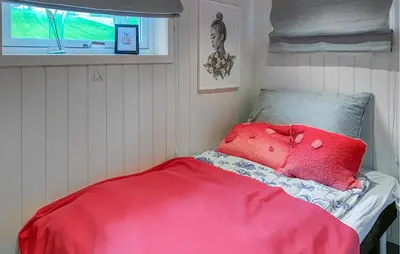 a bed in a room with a red blanket at Gorgeous Home In Sørbøvågen With Wifi in Saltbu