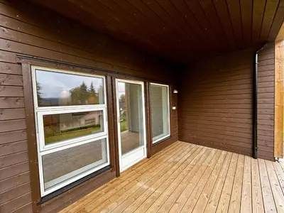 a room with two windows and a wooden deck at Modern apartment with two bedrooms in Moelv
