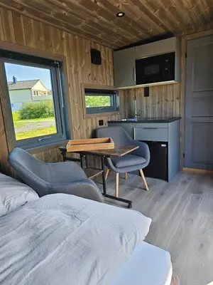 a room with a bed and a table and chairs at WayCamp Tustna in Leira