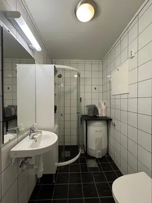 a bathroom with a sink and a shower and a toilet at Cozy Apartment - Great View! in Håra