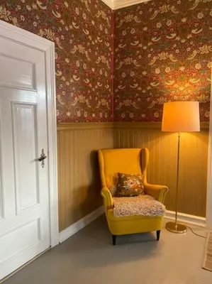 a yellow chair in a room with a lamp at Historisk villa med klassiske detaljer in Snertingdal