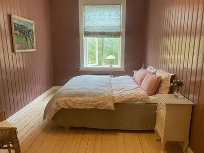 a bedroom with a large bed with a window at Historisk villa med klassiske detaljer in Snertingdal
