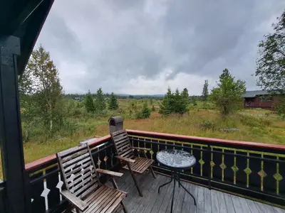 two chairs and a table on a deck with a view at Trollbu by Norgesbooking - cabin at Golsfjellet in Sanderstølen
