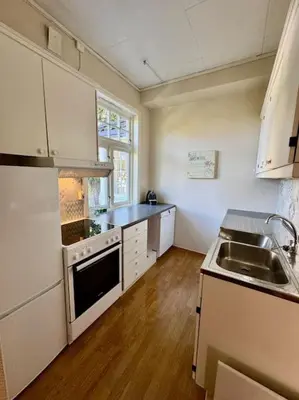 a kitchen with a sink and a stove top oven at Leilighet i herskapelig villa in Trondheim