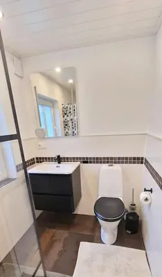 a bathroom with a black and white toilet and a sink at Haus Soltun-Was will man mehr! in Runde