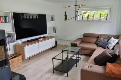 a living room with a couch and a large television at Haus Soltun-Was will man mehr! in Runde