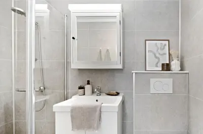 a bathroom with a white sink and a shower at Koselig leilighet ved Solsiden in Trondheim