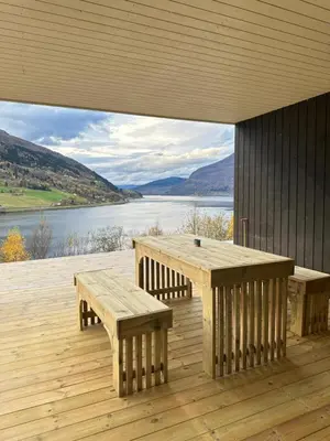 a wooden deck with benches and a view of a lake at Olden Apartment with Panorama view in Olden