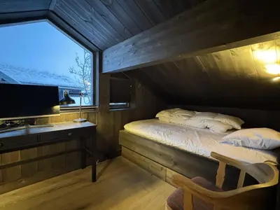 a bedroom with a bed and a desk and a window at Spacious, exclusive and modern cabin in Geilo in Geilo