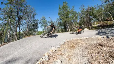 two people riding bikes down a road at Exclusive Ski In-Out apartment in Hemsedal next to Fyri Resort in Hemsedal